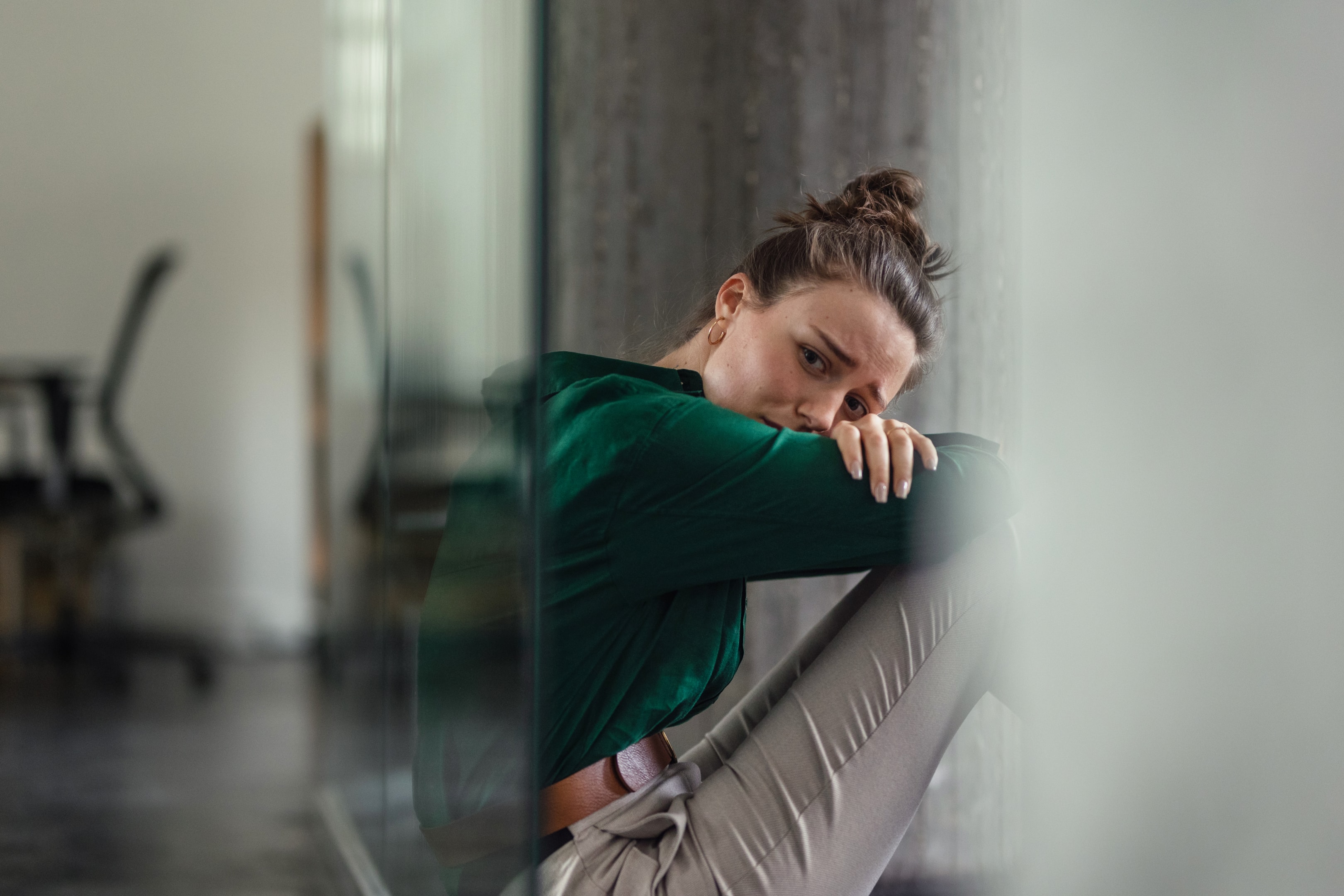 A woman with her head down, illustrating the physical exhaustion and emotional burden of asking,Managing Depression Symptoms in The Woodlands