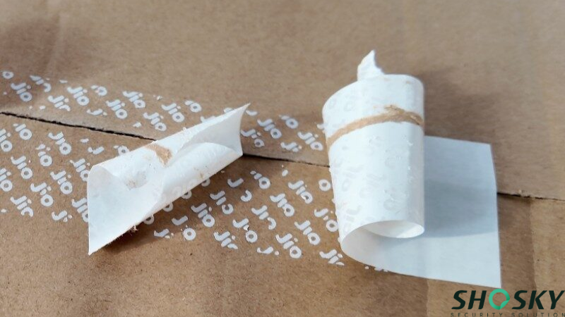 Permanent adhesive label delaminating and leaving residue on a shipping box