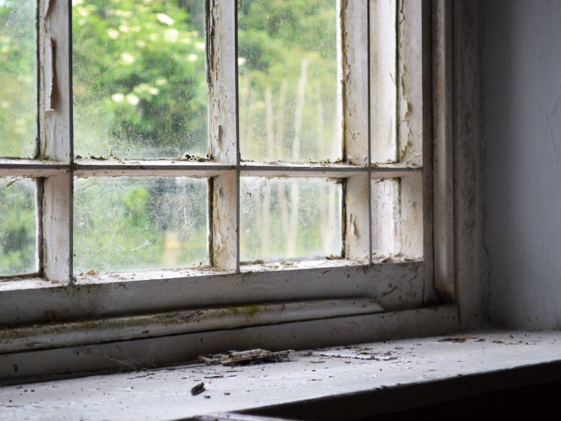 An image showing a window that is showing wear and tear, needing replacement. 