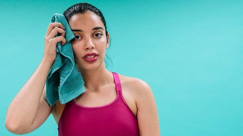A girl wiping sweat with a gym towel