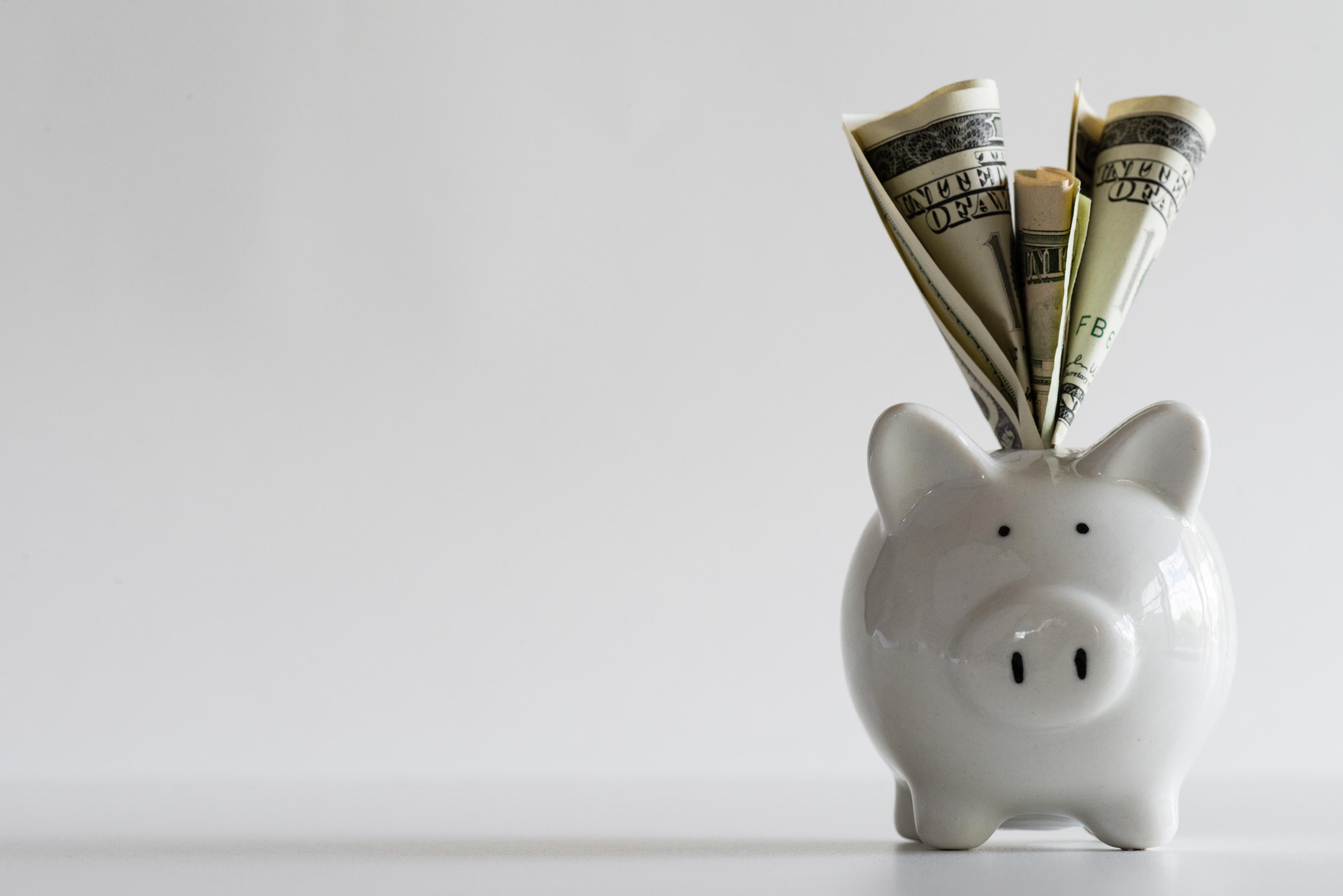 A piggy bank with dollar bills sticking out illustrates the cocaine addiction treatment cost