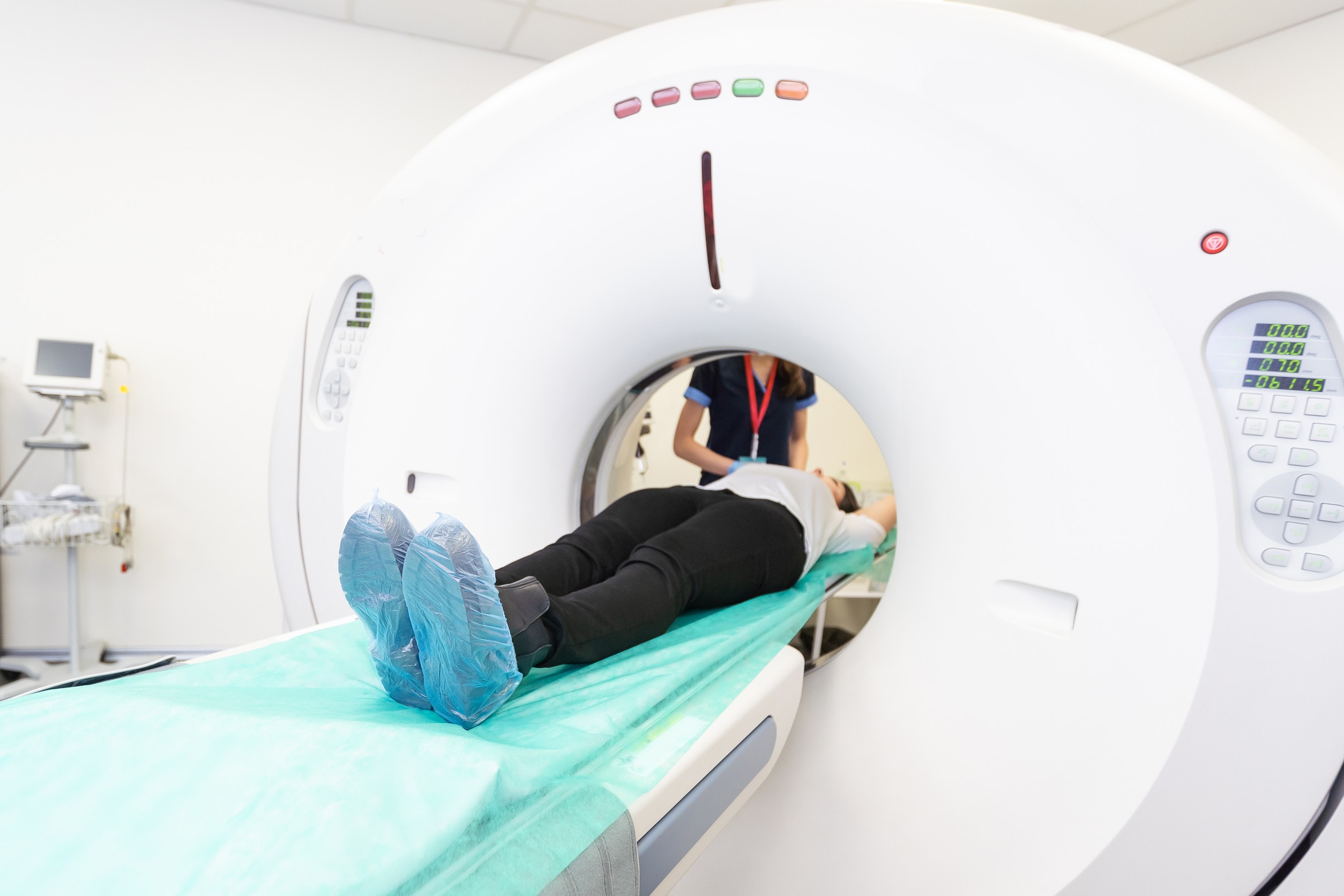A patient laying in an MRI machine and talking to a healthcare professional after an incorrect or delayed diagnosis.