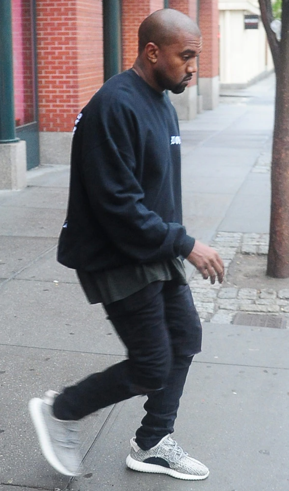 Kanye West wearing all black with white Yeezy's