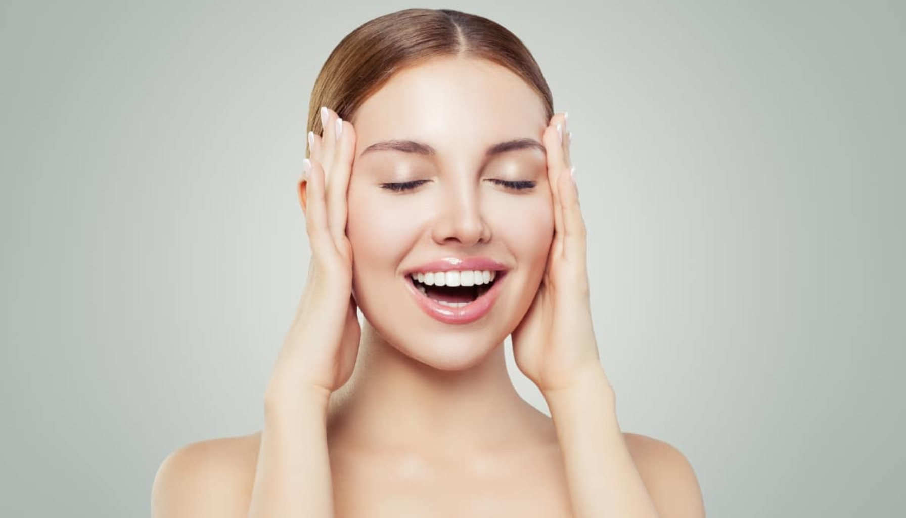 Smilende kvinne viser rette tenner etter tannregulering hos kjeveortoped i Oslo.