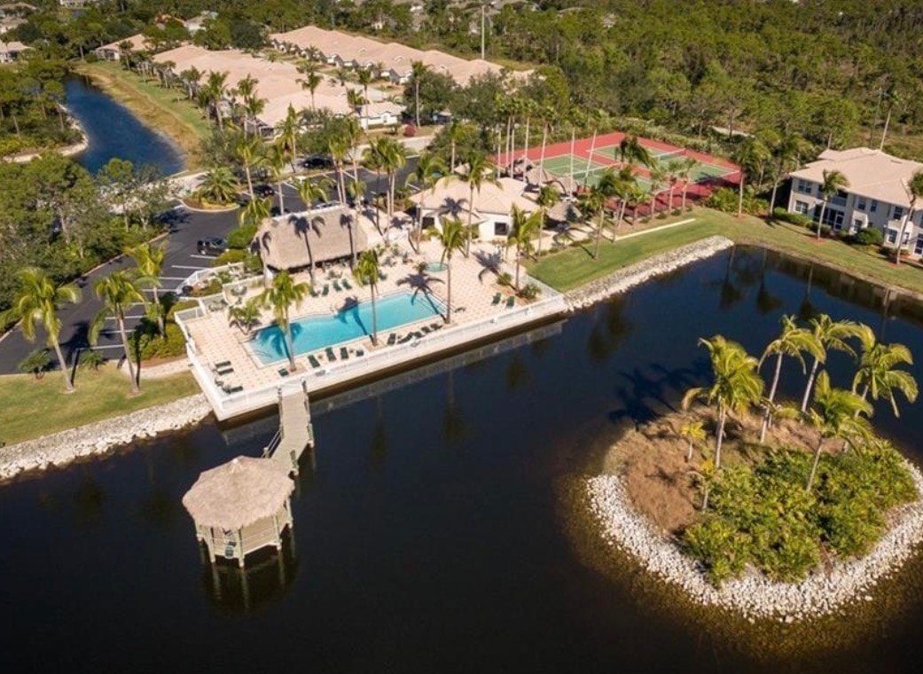 The image depicts the entrance of a gated community, featuring lush landscaping and security features that ensure privacy and safety. This inviting setting is characteristic of the Coconut Shores community, offering a glimpse into the serene lifestyle of Southwest Florida living.