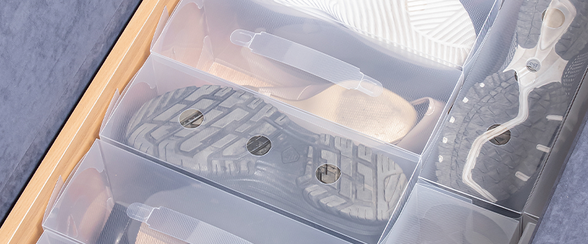 A close up of some Artiss clear shoe box storage cases in an under bed storage container. 