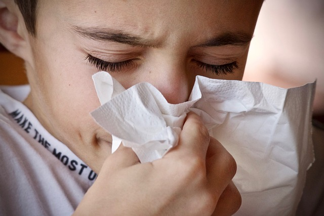 How to Clean Your Throat An image of a young person blowing their nose into a tissue.