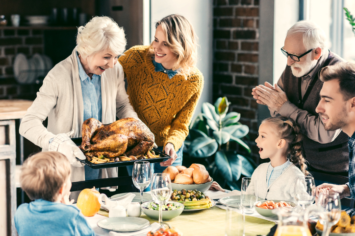 Grandma, grandpa, and family sitting around the Thanksgiving table. 