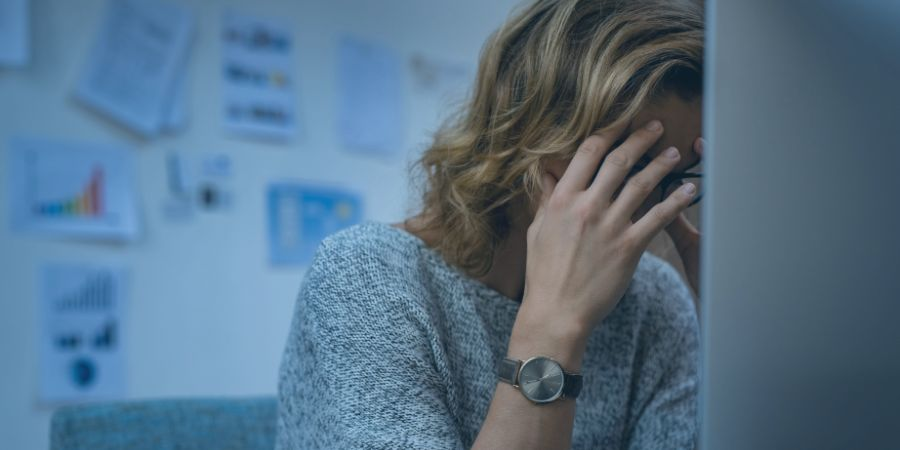 Woman with head in her hands at computer