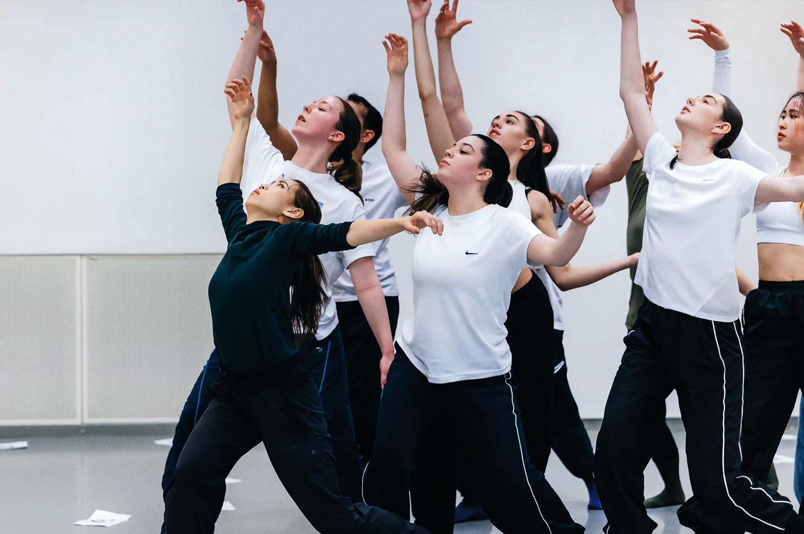 Contemporary dance group practicing expressive choreography in a studio.