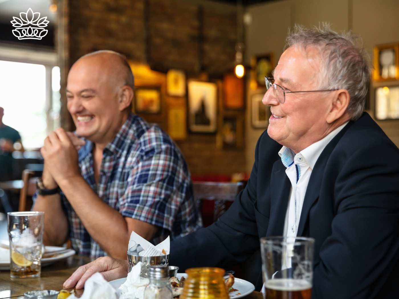 Two older men sharing a laugh over drinks, highlighting the Gift Boxes for Men Collection - One size fits all, with beer glass and gift box options that vary based on preferences - Fabulous Flowers and Gifts