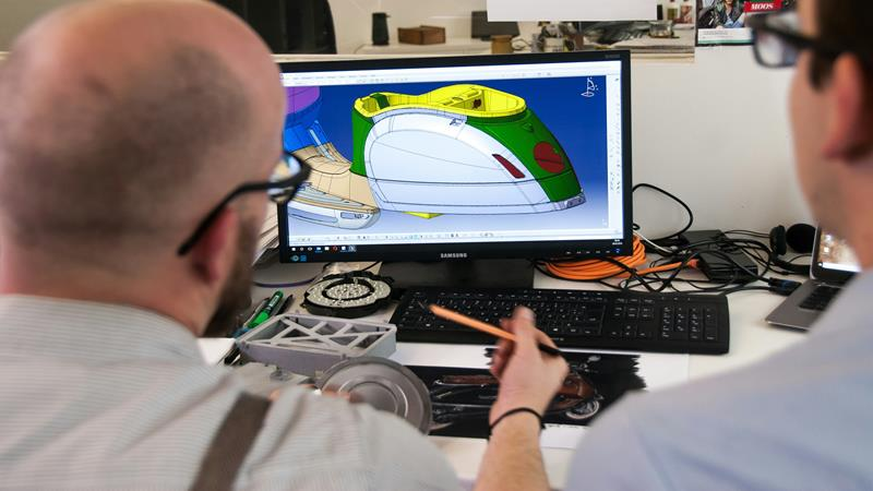 Deux personnes analysant le design sur un écran d'ordinateur.