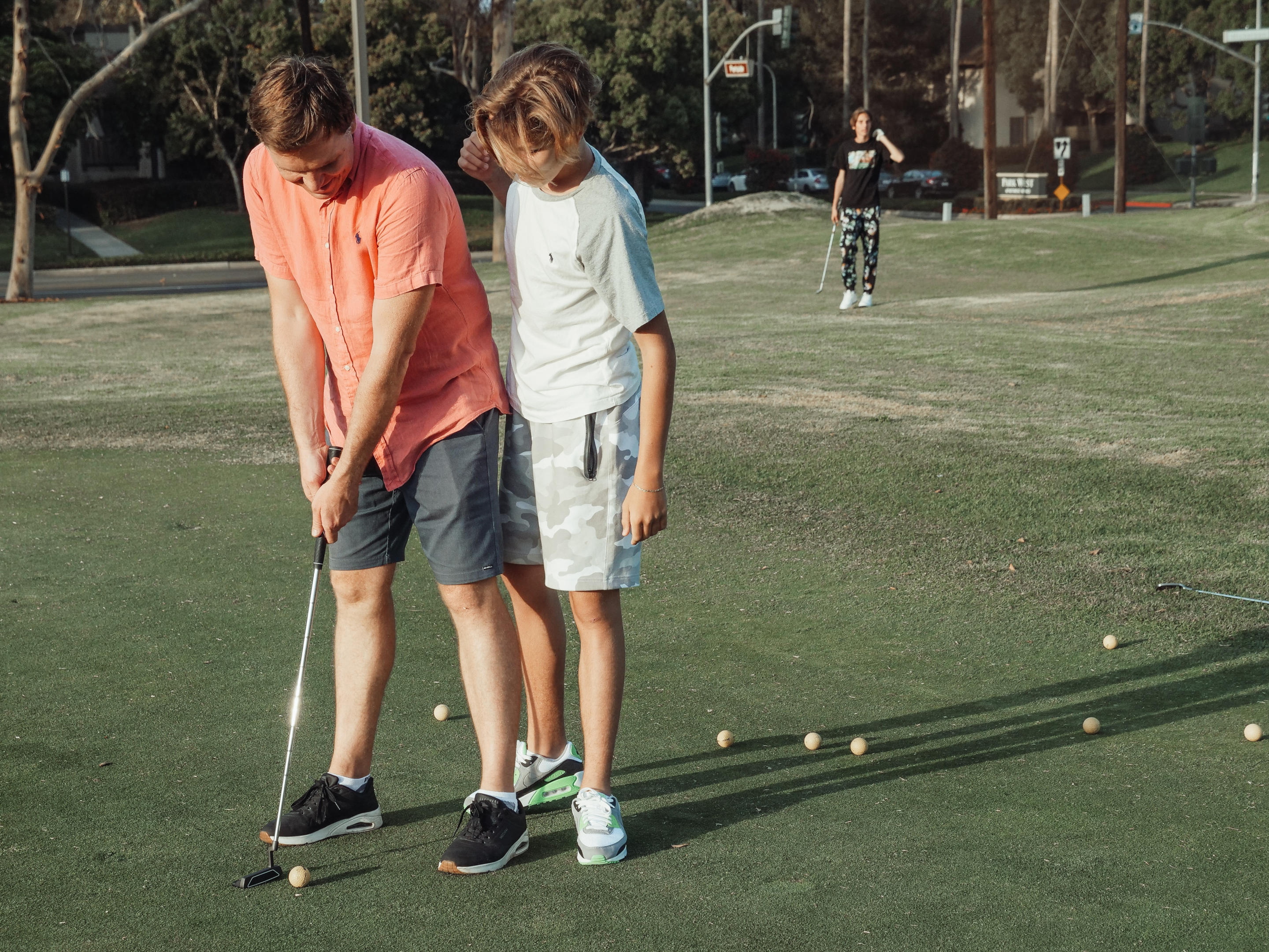 golf pro teaching kids a fundamental of making a golf shot