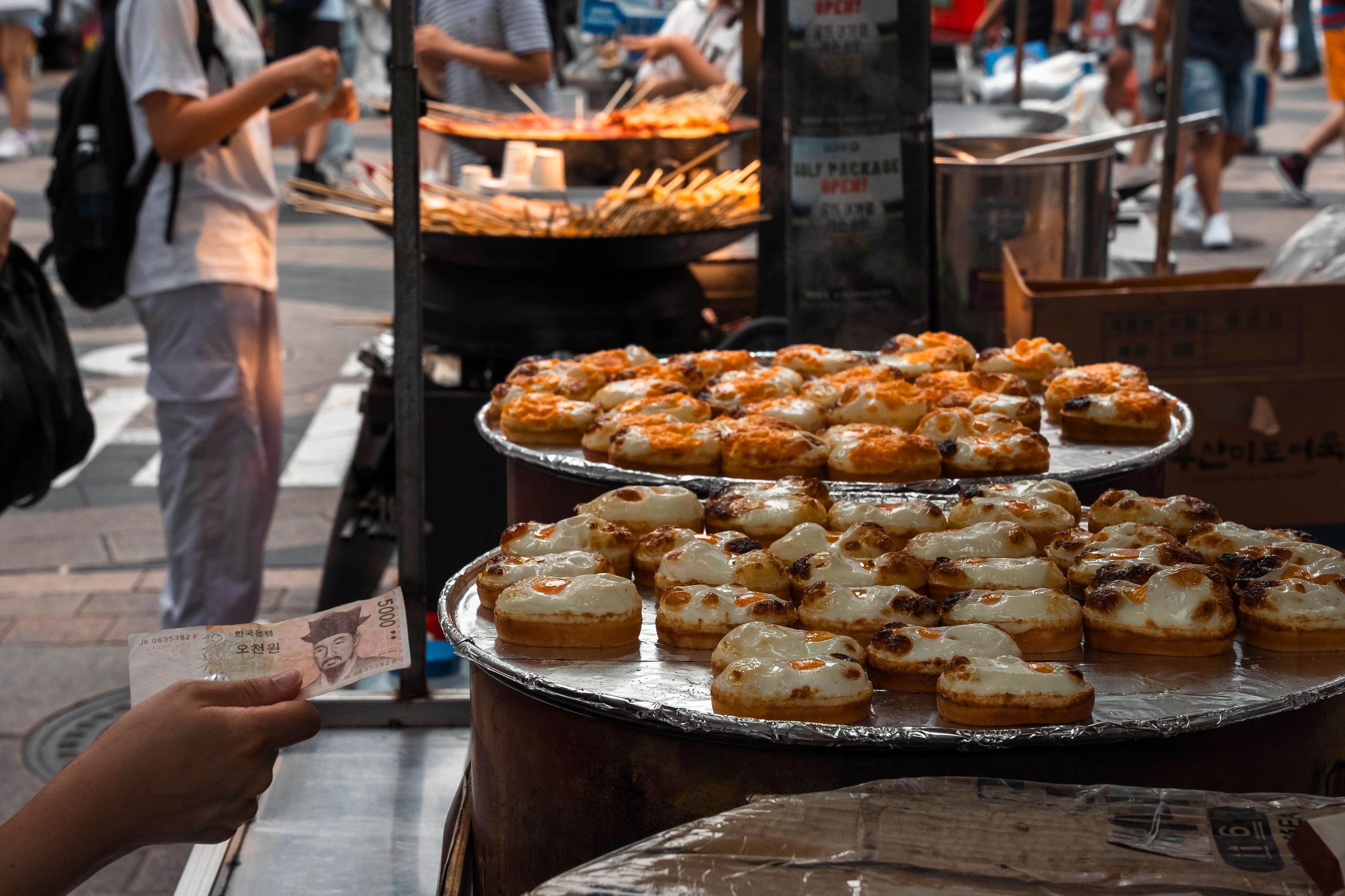 An overhead view showcases a colorful array of street food dishes, including tacos, dumplings, and skewers, beautifully arranged on a rustic table, reflecting the vibrant dining experience found in many restaurants. This image captures the essence of emerging food trends, appealing to diverse tastes and preferences.