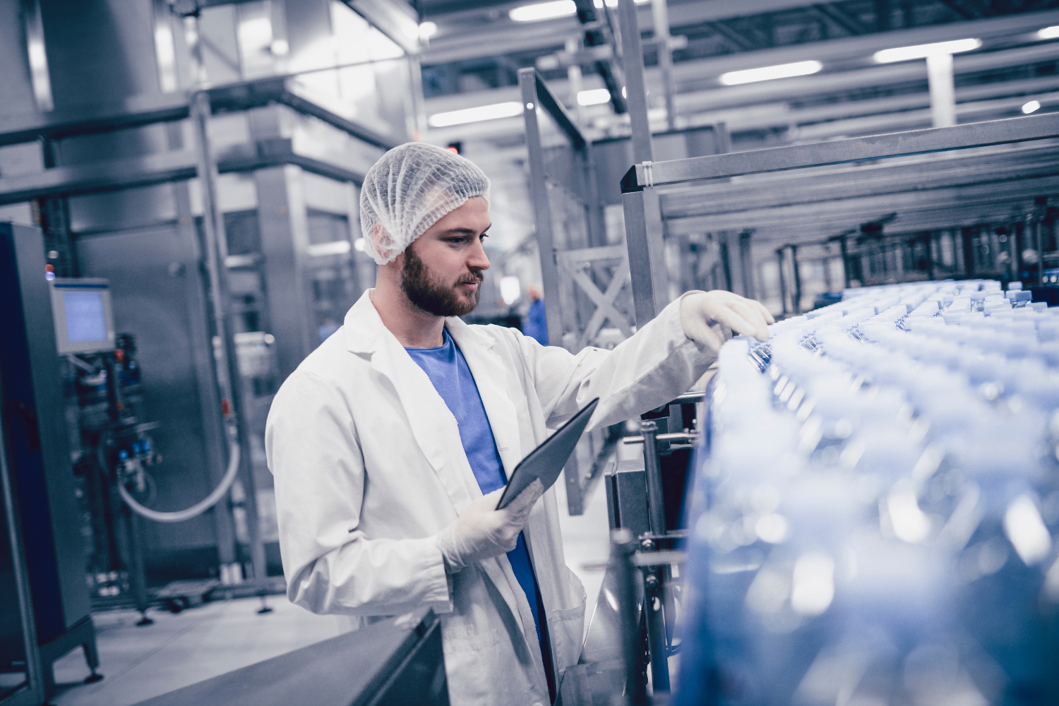 A clean supplement production line with a quality control inspector.