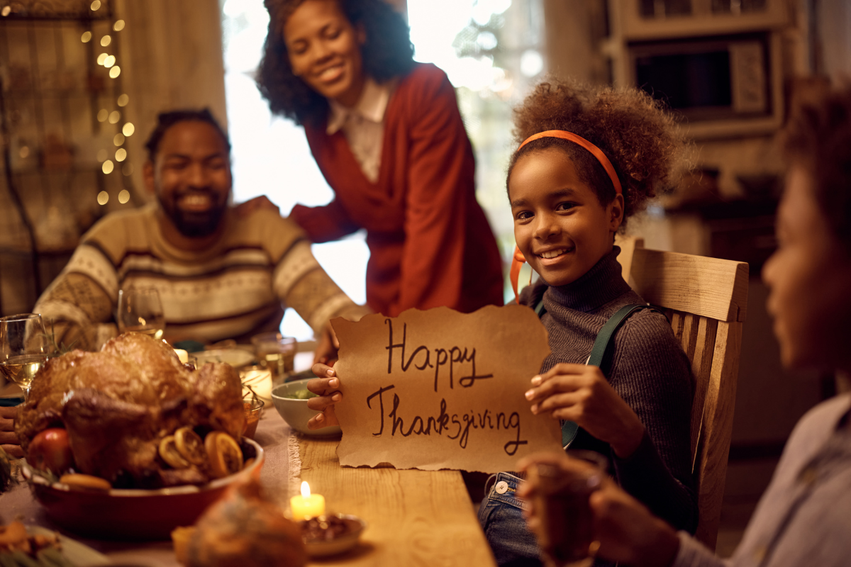 A family gathered around a beautifully set Thanksgiving dinner table, sharing warm wishes and heartfelt messages.