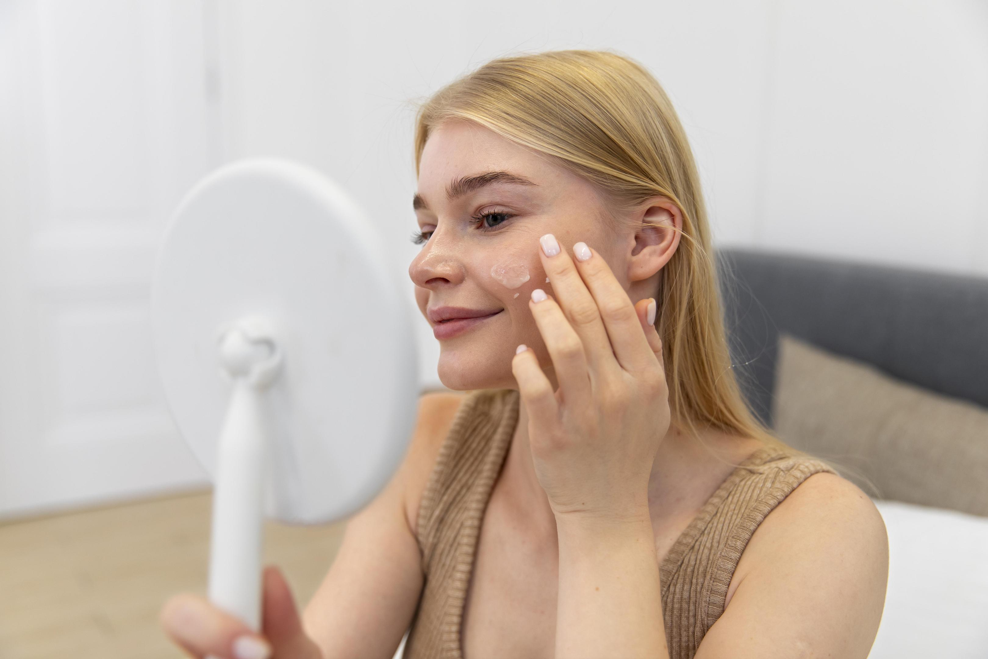 woman applying cream to her face