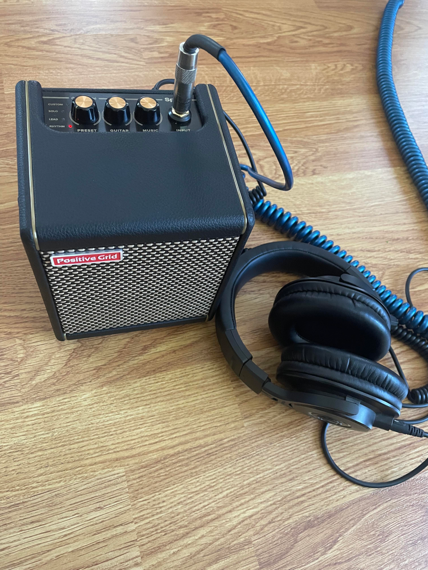 A PositiveGrid Spark Mini amp with headphones.