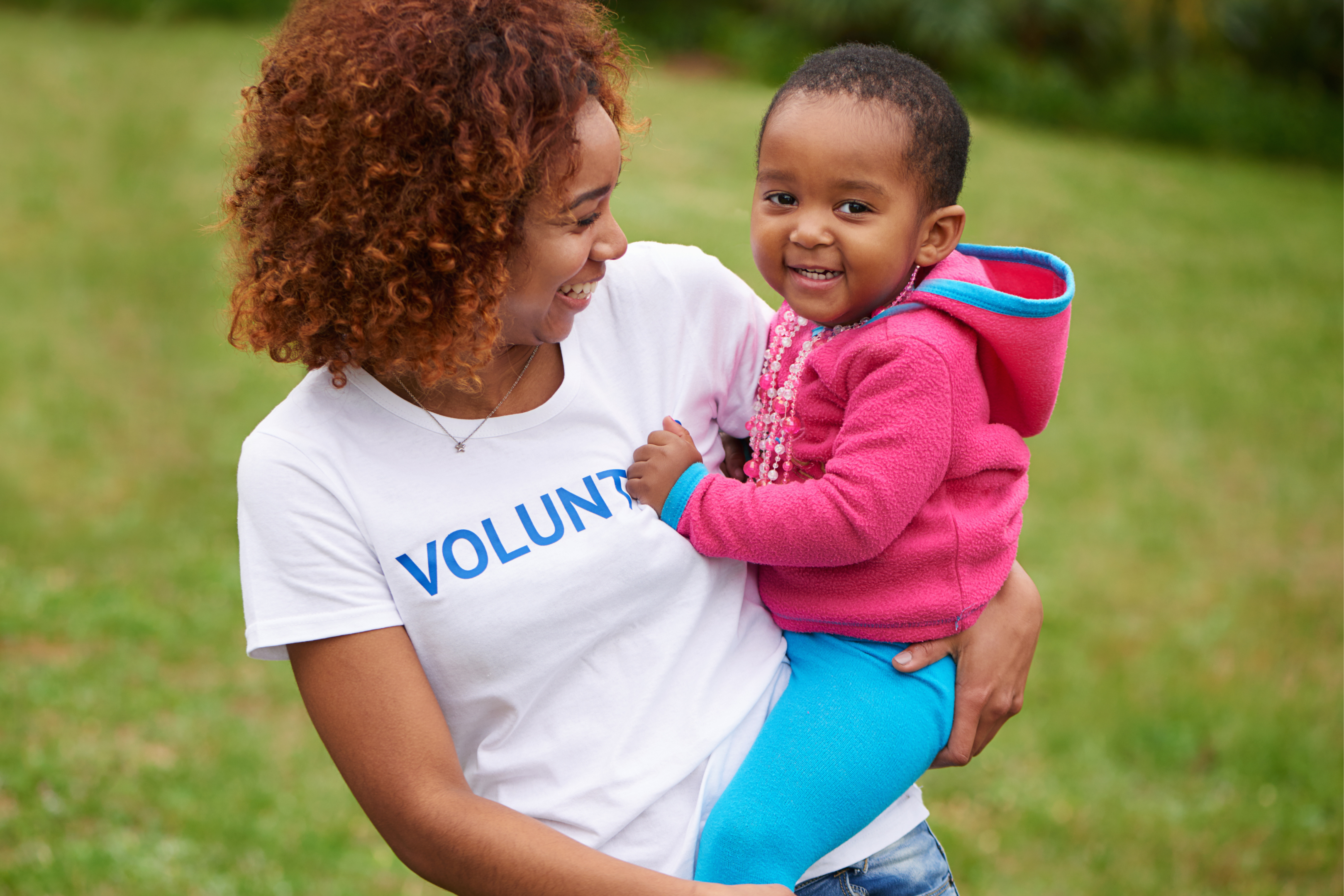 women in a volunteer shirt holding an infant