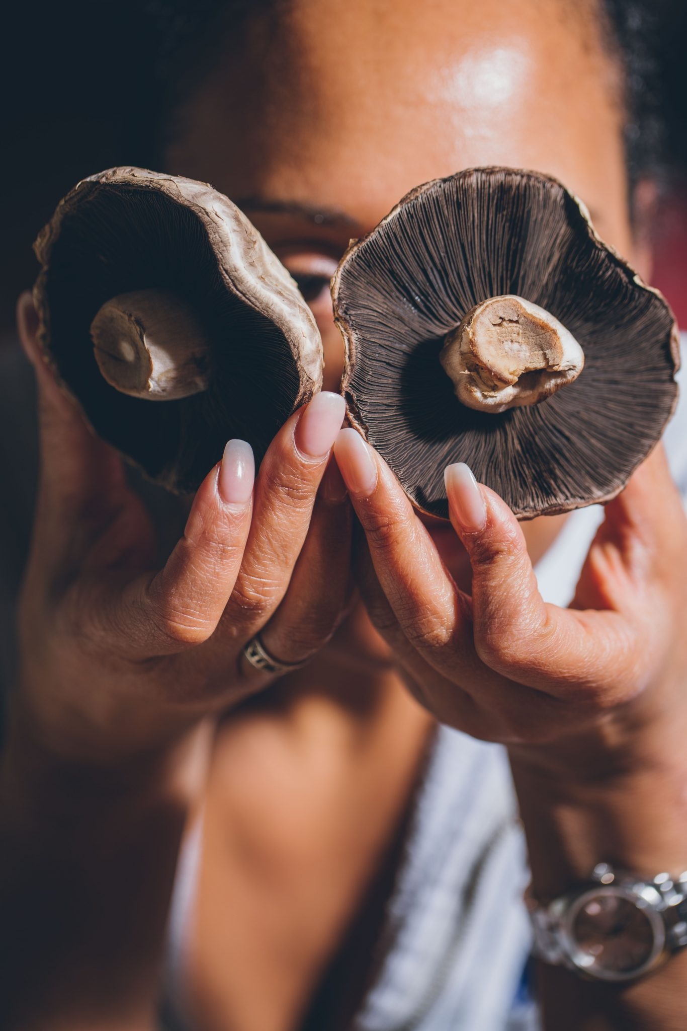 Commercial photo of a woman holding two mushrooms
