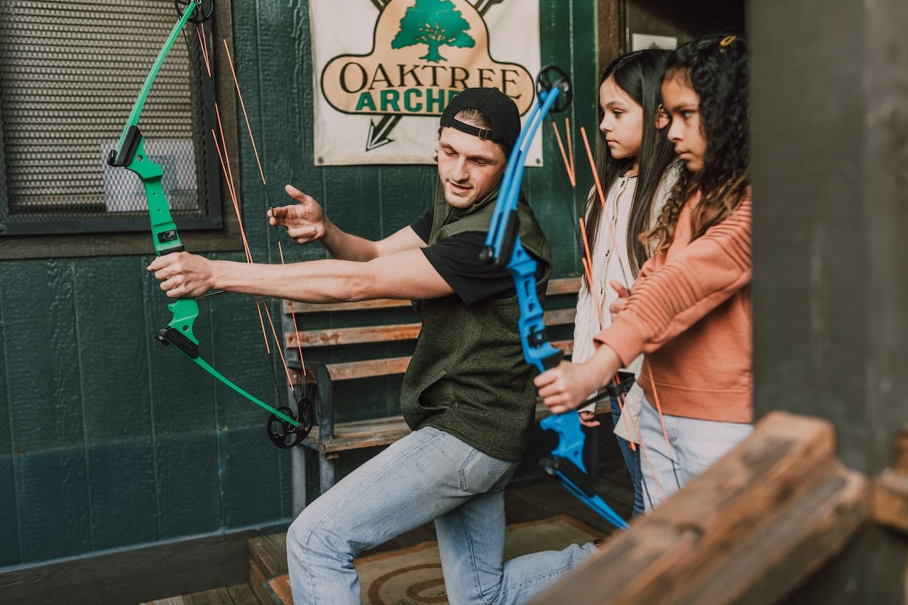 Young girls learning to shoot a youth compound bow