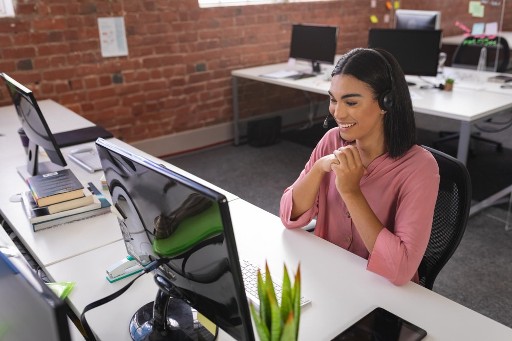 Young adult woman a at desk taking inbound calls through a desktop app.