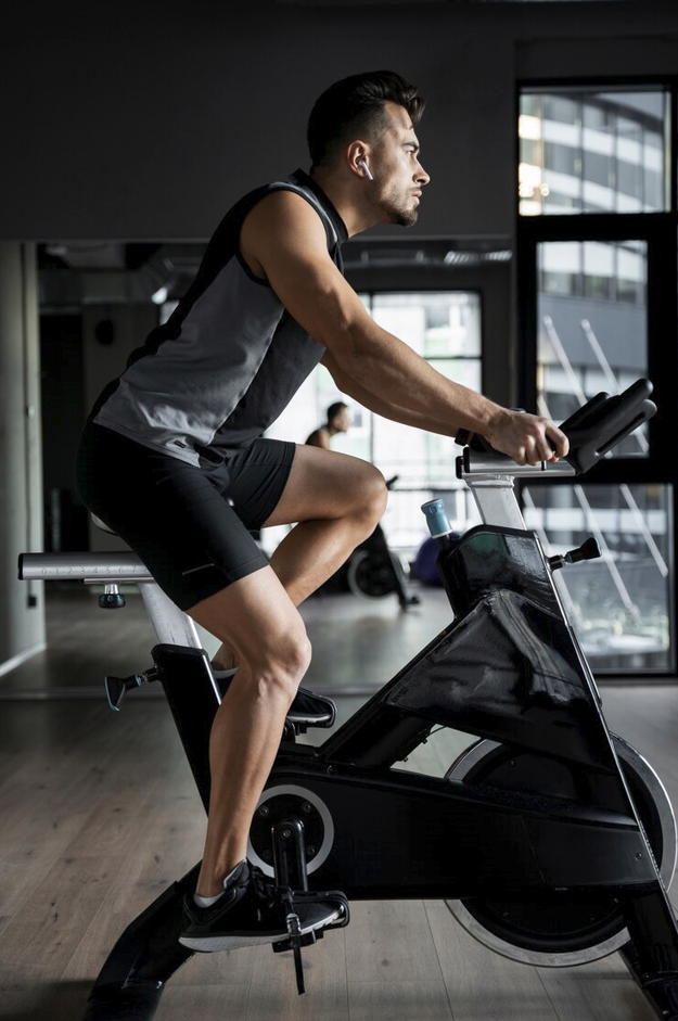 Man tränar på motionscykel från HE Fitness – fokuserad konditionsträning med magnetiskt motstånd.