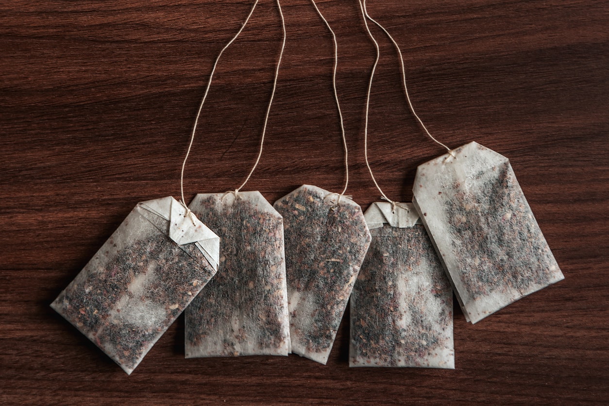 Green tea bath tea bags on wooden surface, herbal soak sachets for natural detox and spa treatment