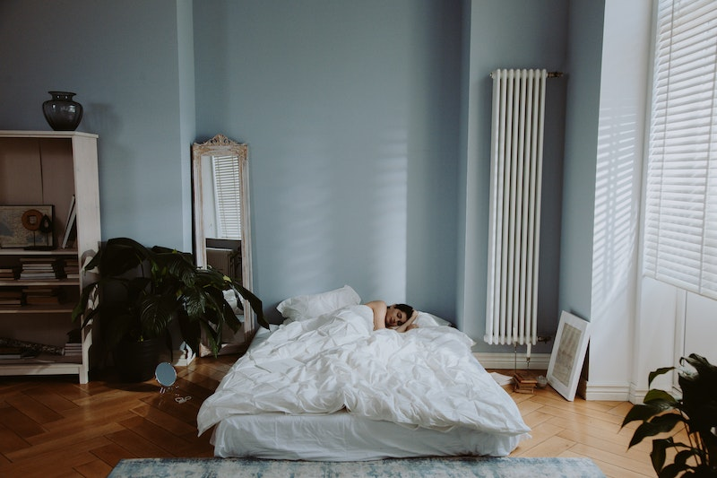 Ultimate Guide To Meditation For Sleep: Woman sleeping on a bed in a minimal room
