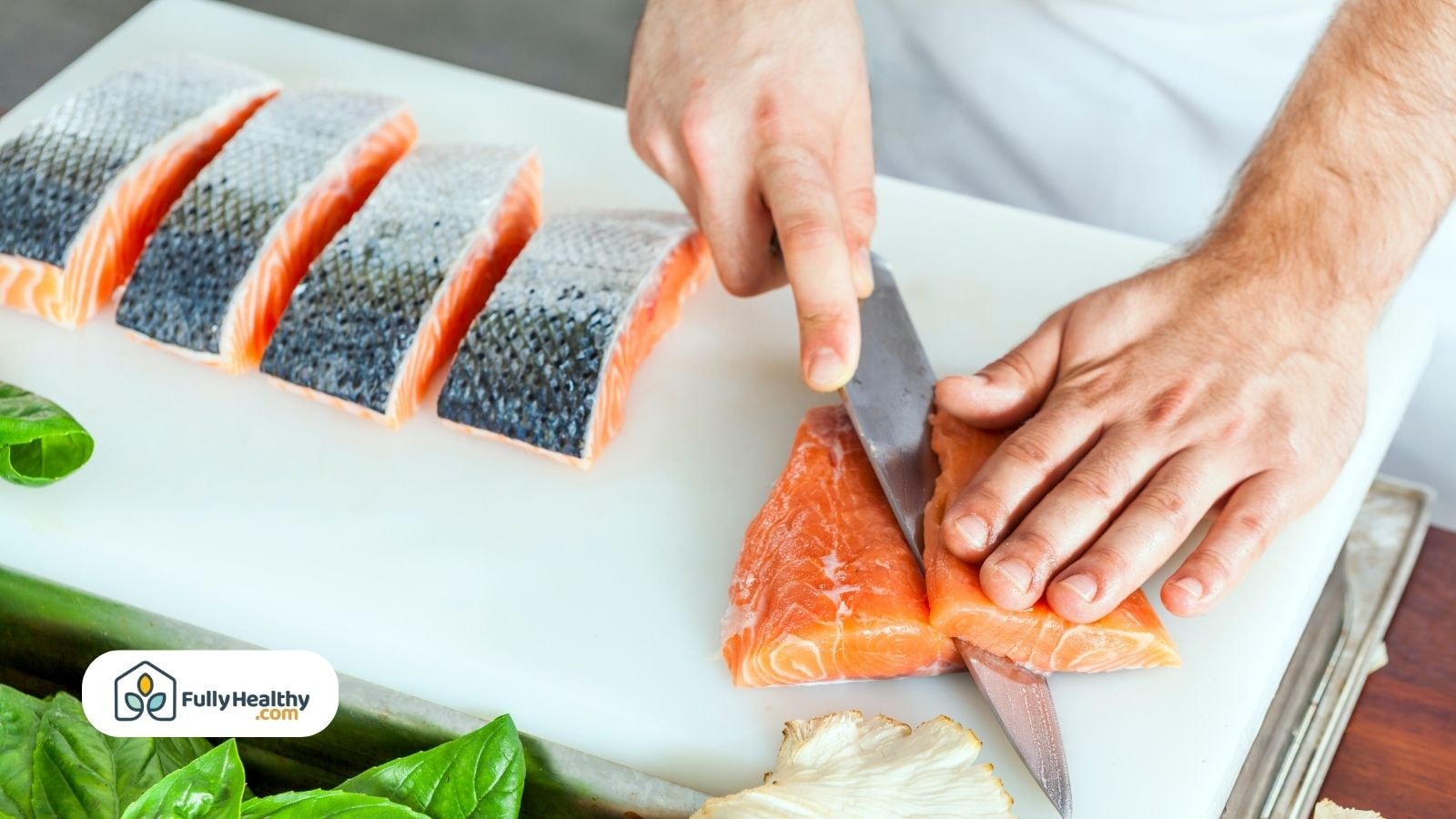 A person cutting fresh salmon fillet on board with sliced portions ready to cook