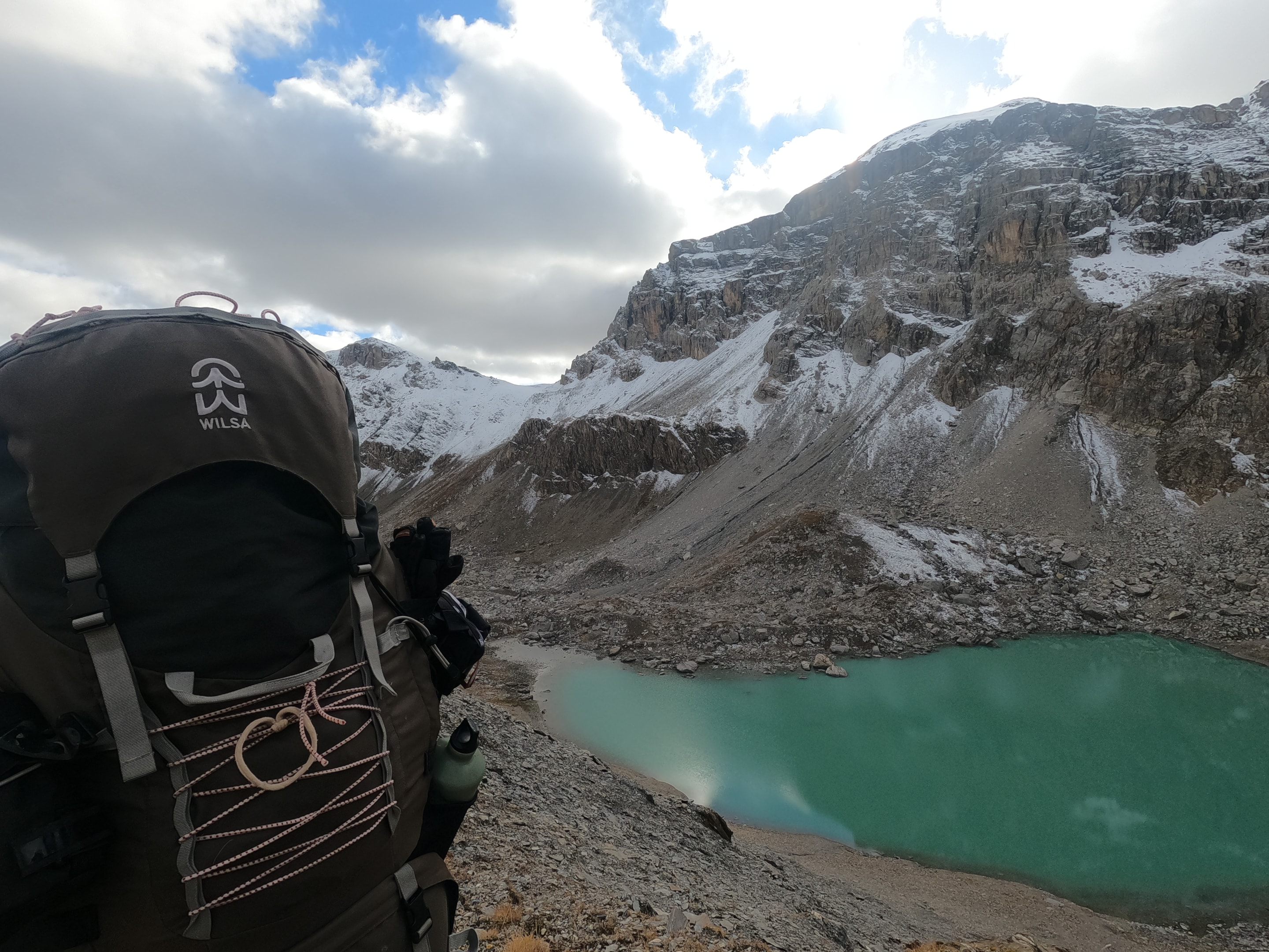 sac à dos de randonnée dans un décor de montagne avec lac sous la neige