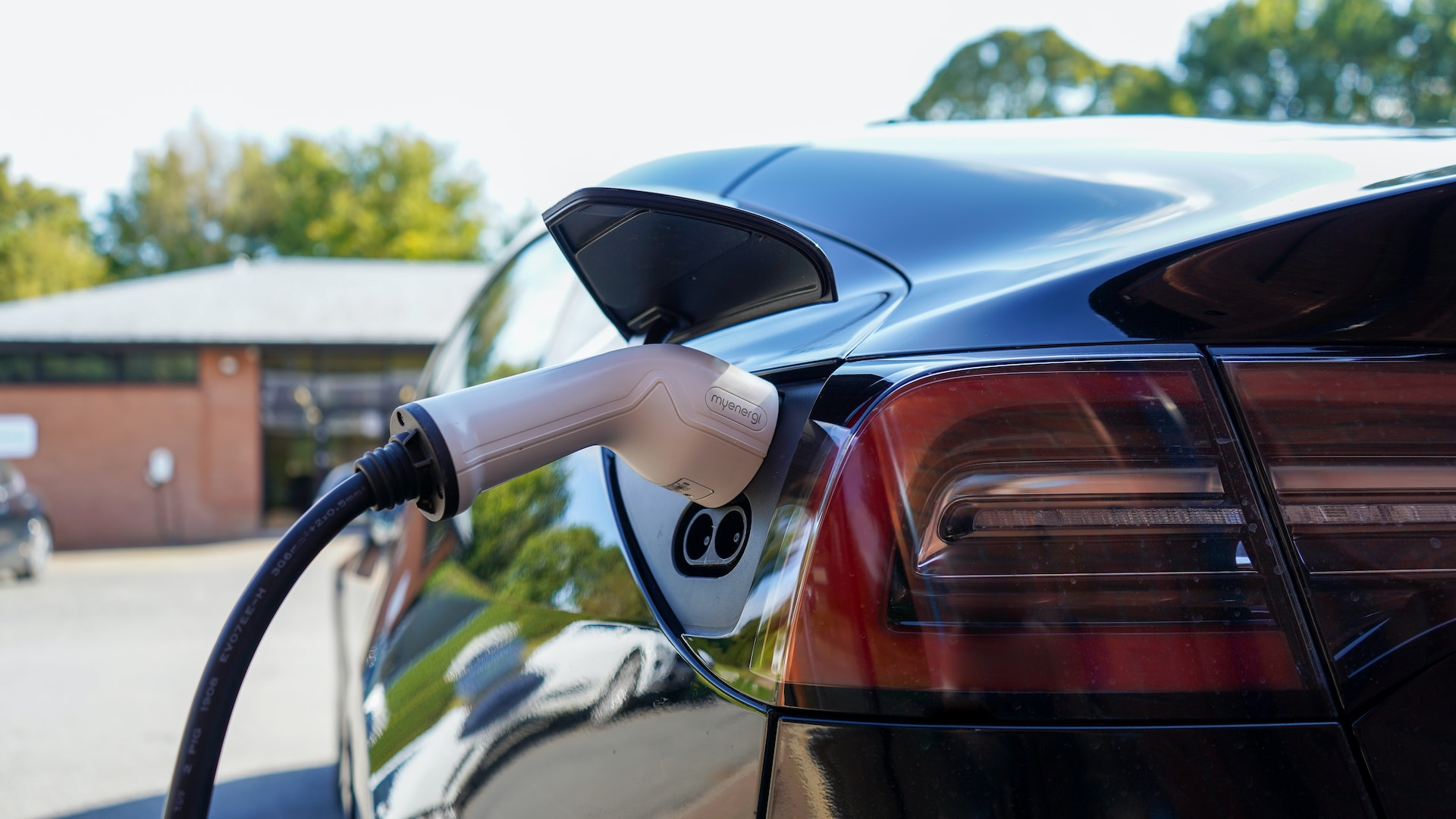 A man plugging an electric vehicle into a level 2 ev charger