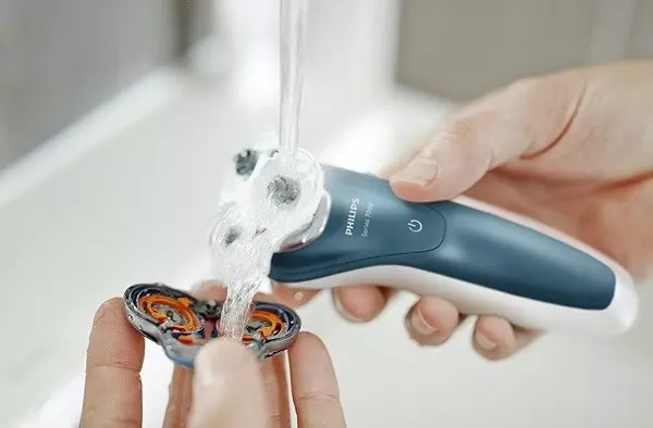 A person doing electric razor or electric shaver maintenance with liquid soap and normal battery temperature for extended battery life
