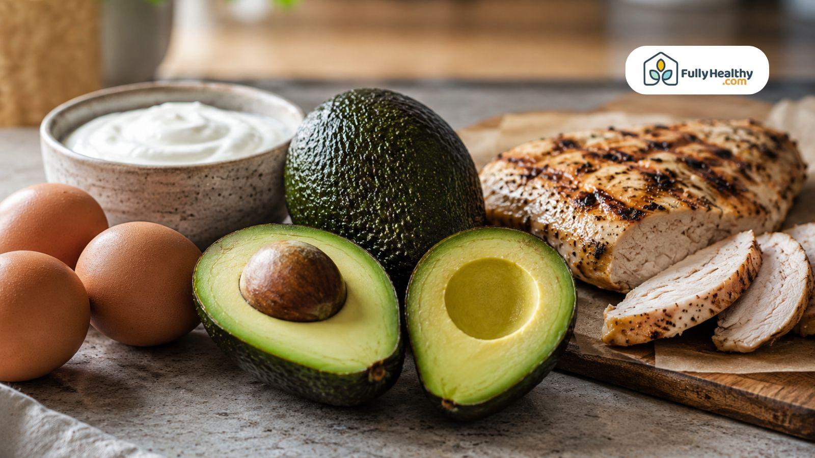 Whole and sliced avocado beside eggs, greek yogurt, and grilled chicken.