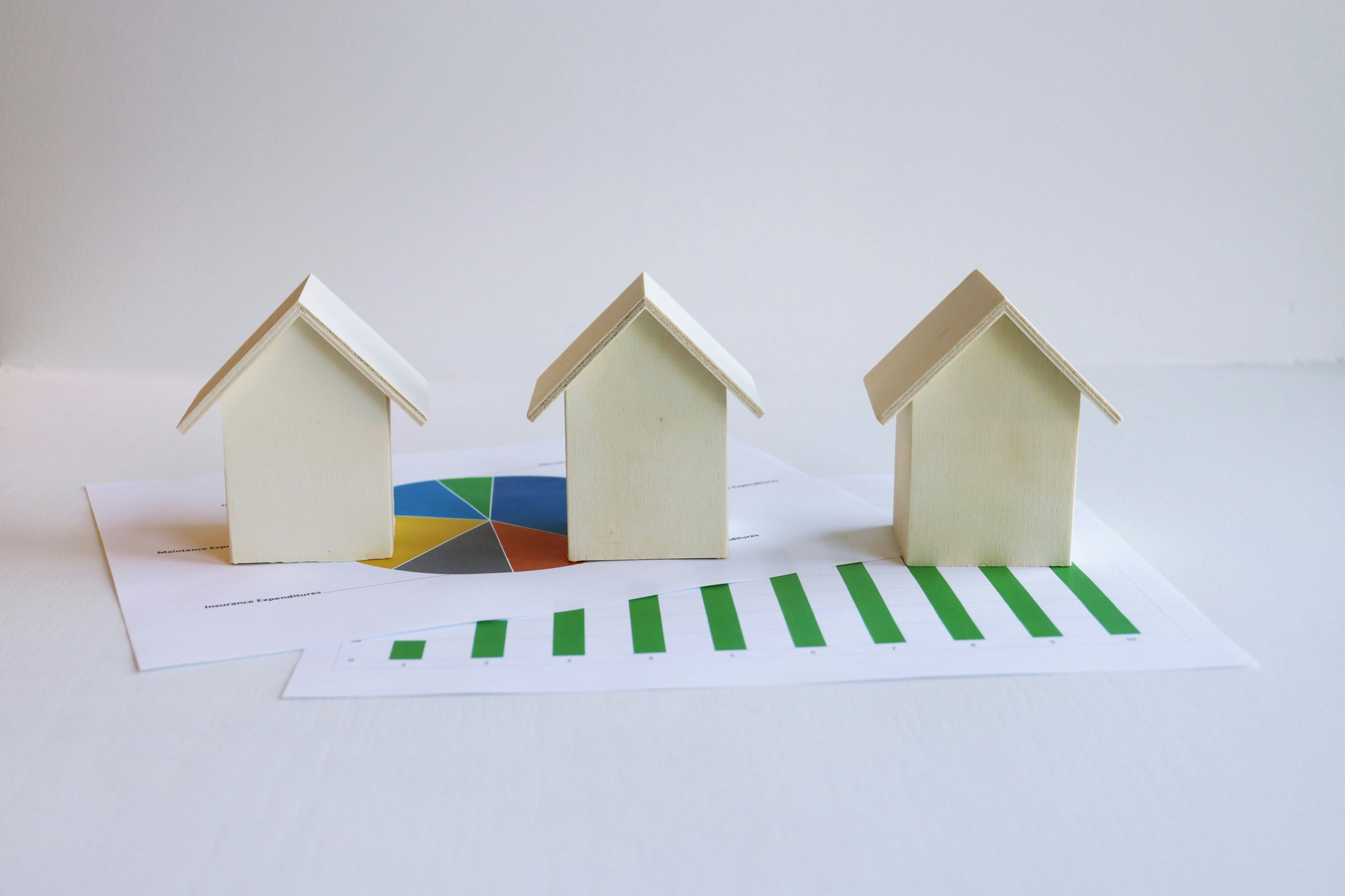 Models of small houses alongside graphs showing elements of property management.