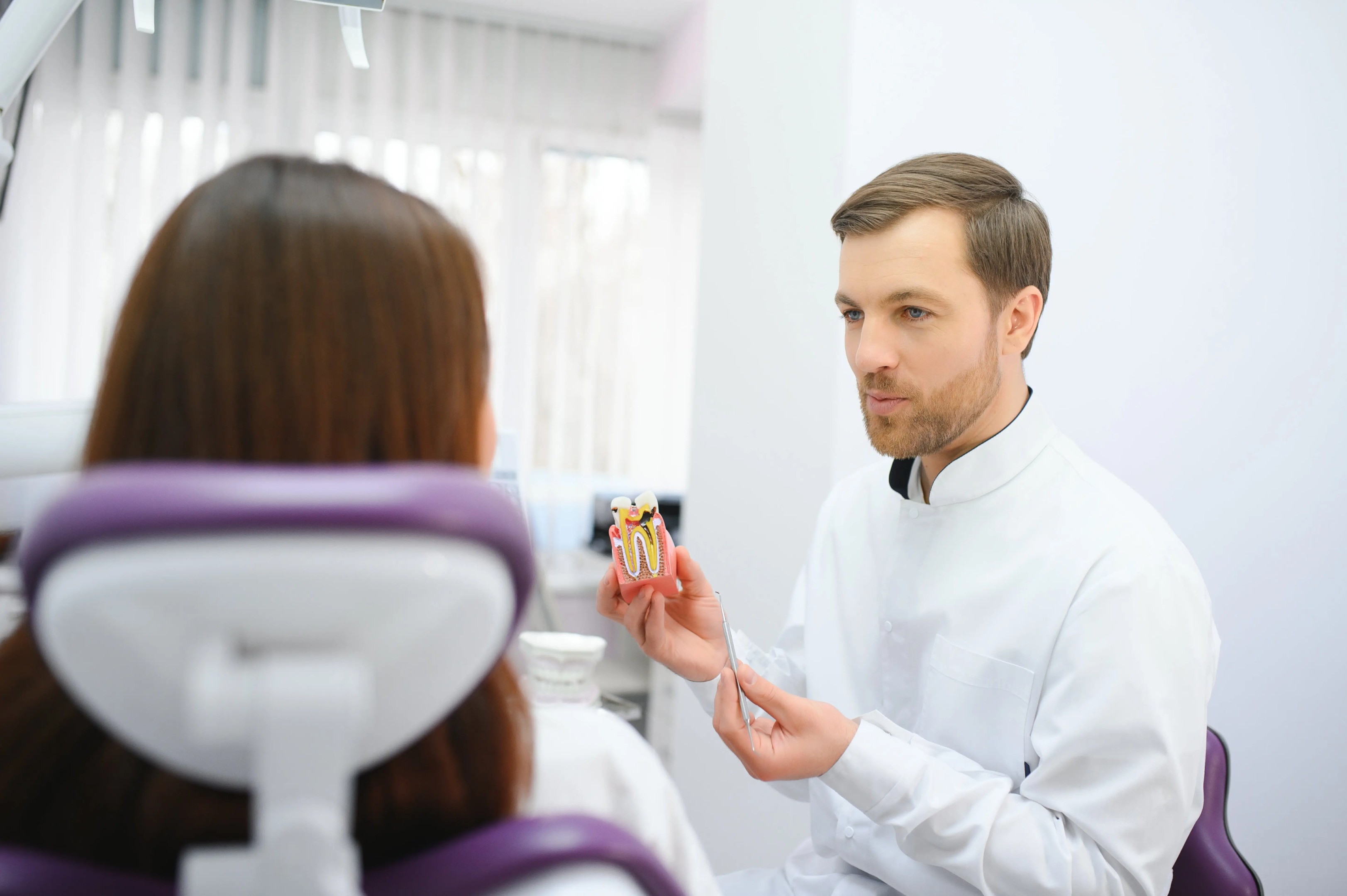 Beautiful young woman having dental treatment at dentist's office.