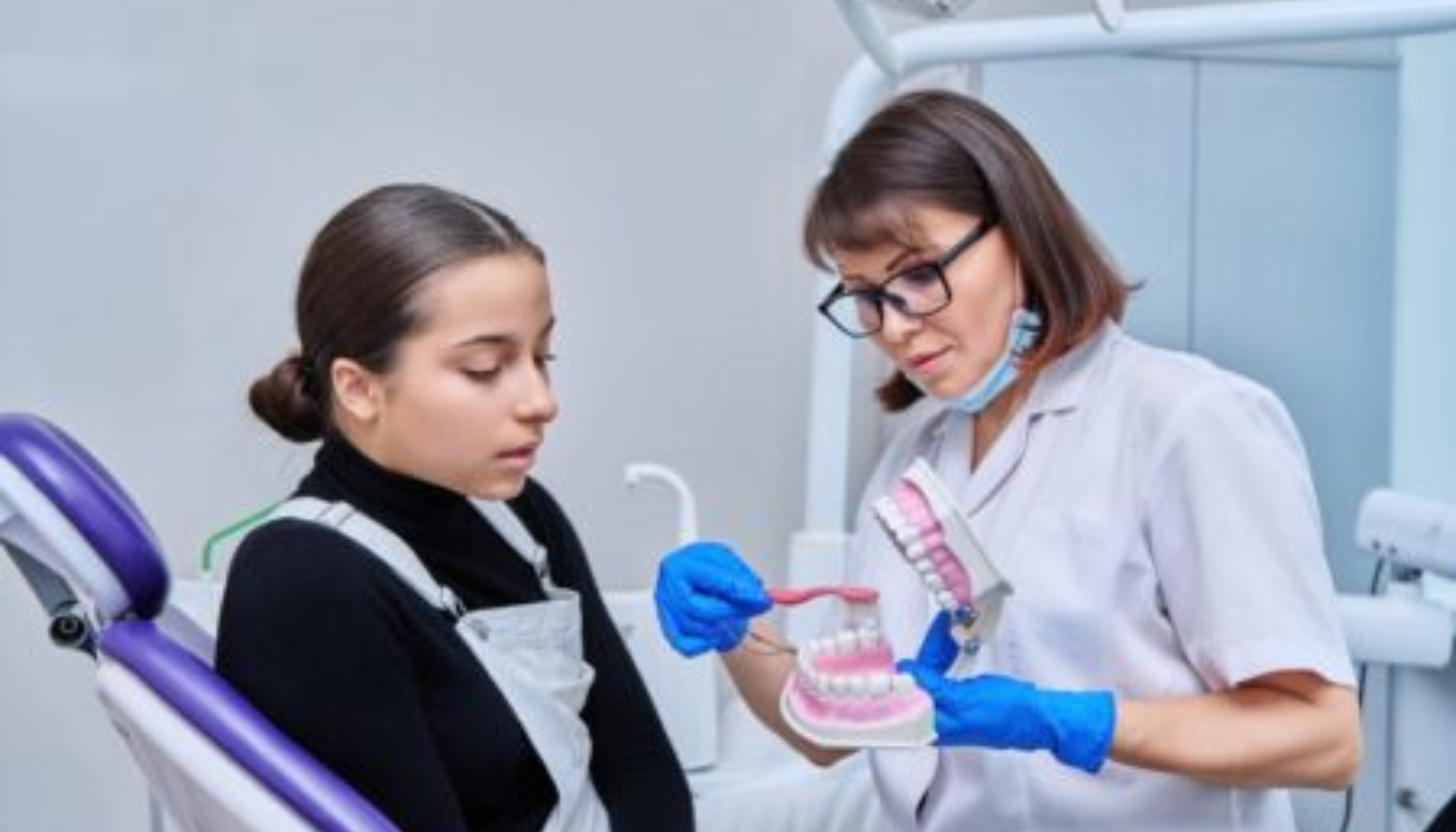 «Tannlege med briller og blå hansker viser tannmodell til ung pasient i tannlegekontor.» helfo europeisk helsetrygdkort refusjon behandling helsetjenester andre mer krav informasjon refusjonskrav behandlere under annet feil veiledning individuell kroner blant flere norske kontroll gir skjema tjenester fått måte tilgang ulike ytre sikre tid får medlemmer eksempel