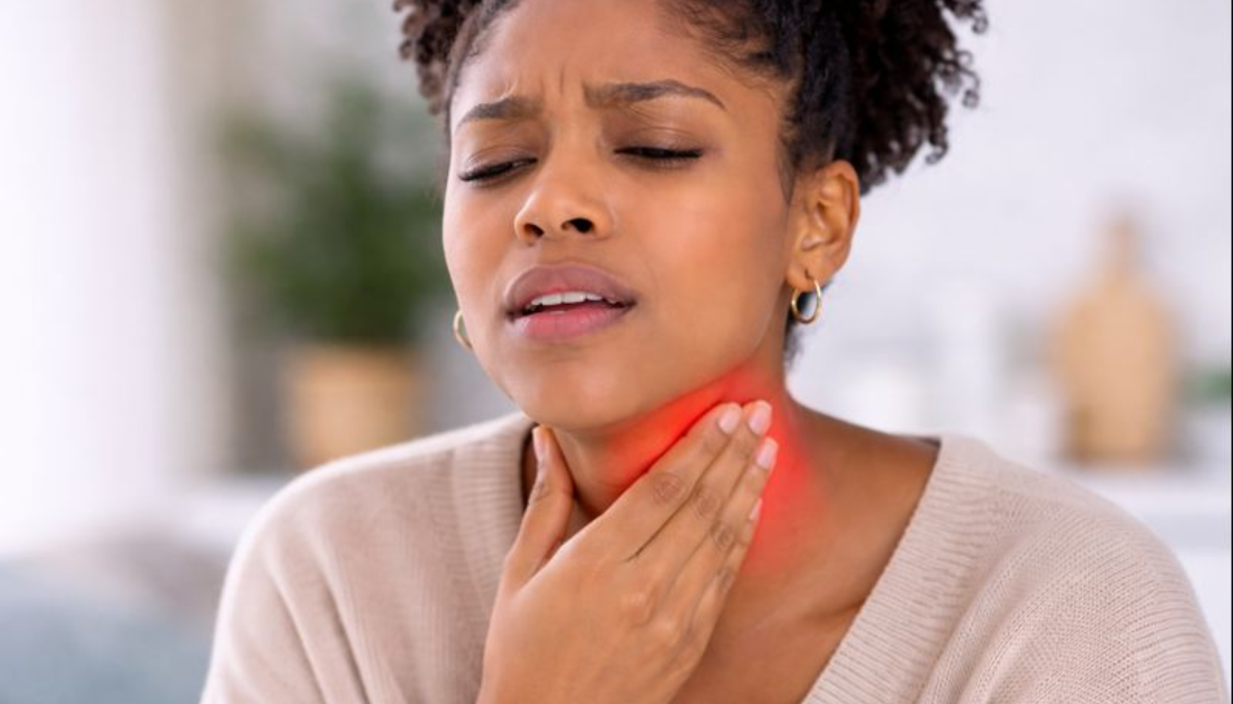 Mandler i Halsen: Når Hevelse Påvirker Munnen og Pusten 11 Kvinne med hovne mandler holder halsen, viser hvordan hevelse kan påvirke munn, svelg og pust.