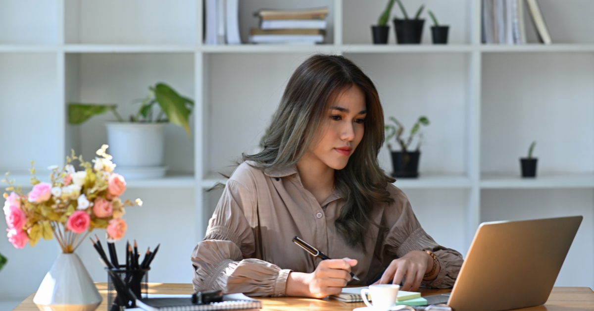 A woman jotting down notes how to update tax details on OnlyFans.