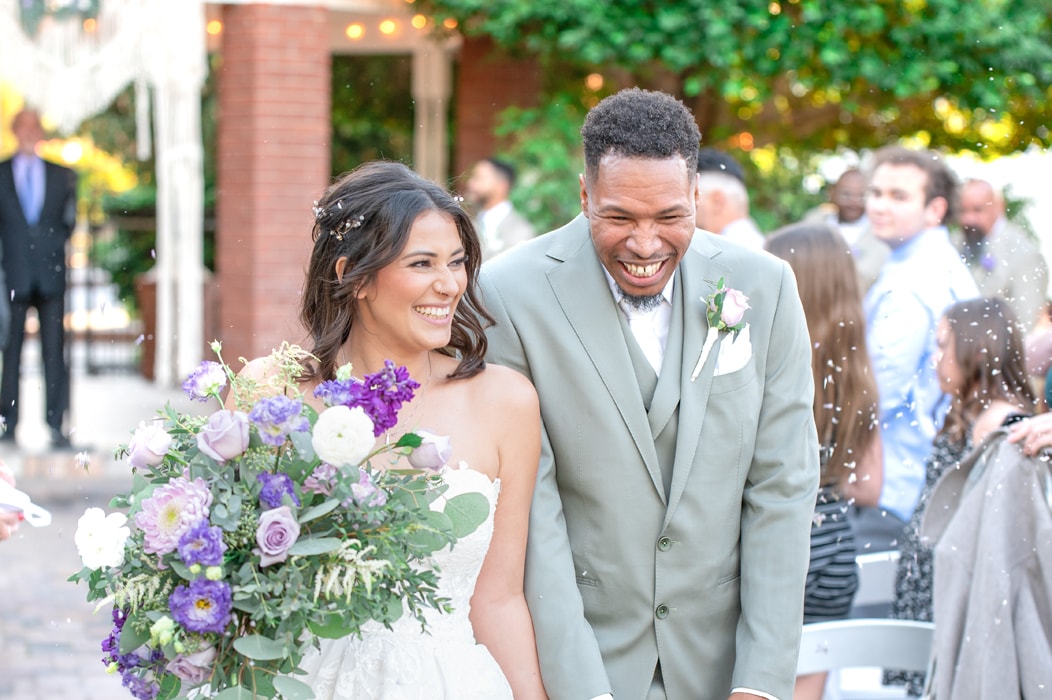 Excited couple walking the isle after getting married on their wedding day.