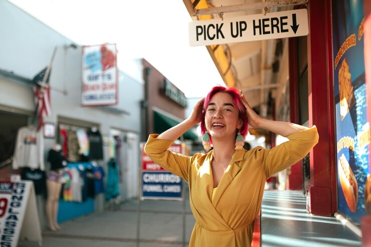 a pink hair Asian woman under a pick up here sign