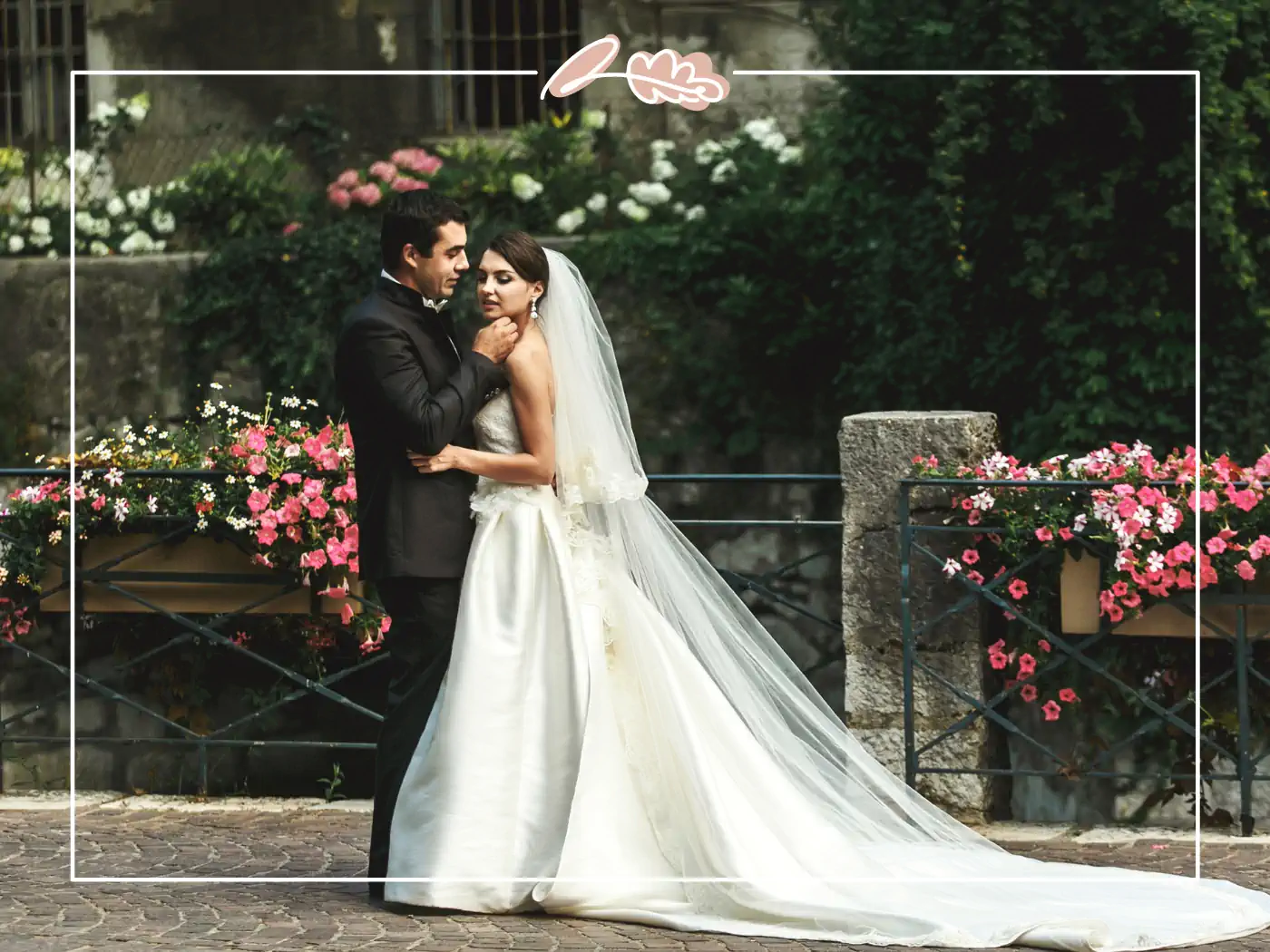 A bride and groom embracing in an elegant outdoor setting with beautiful floral arrangements. Fabulous Flowers and Gifts.