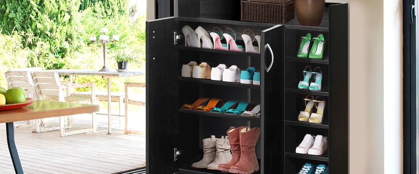 An Artiss Black 2-door Shoe Cabinet, open and showing a variety of colourful shoes. To the left, the room opens onto an outdoor patio. 
