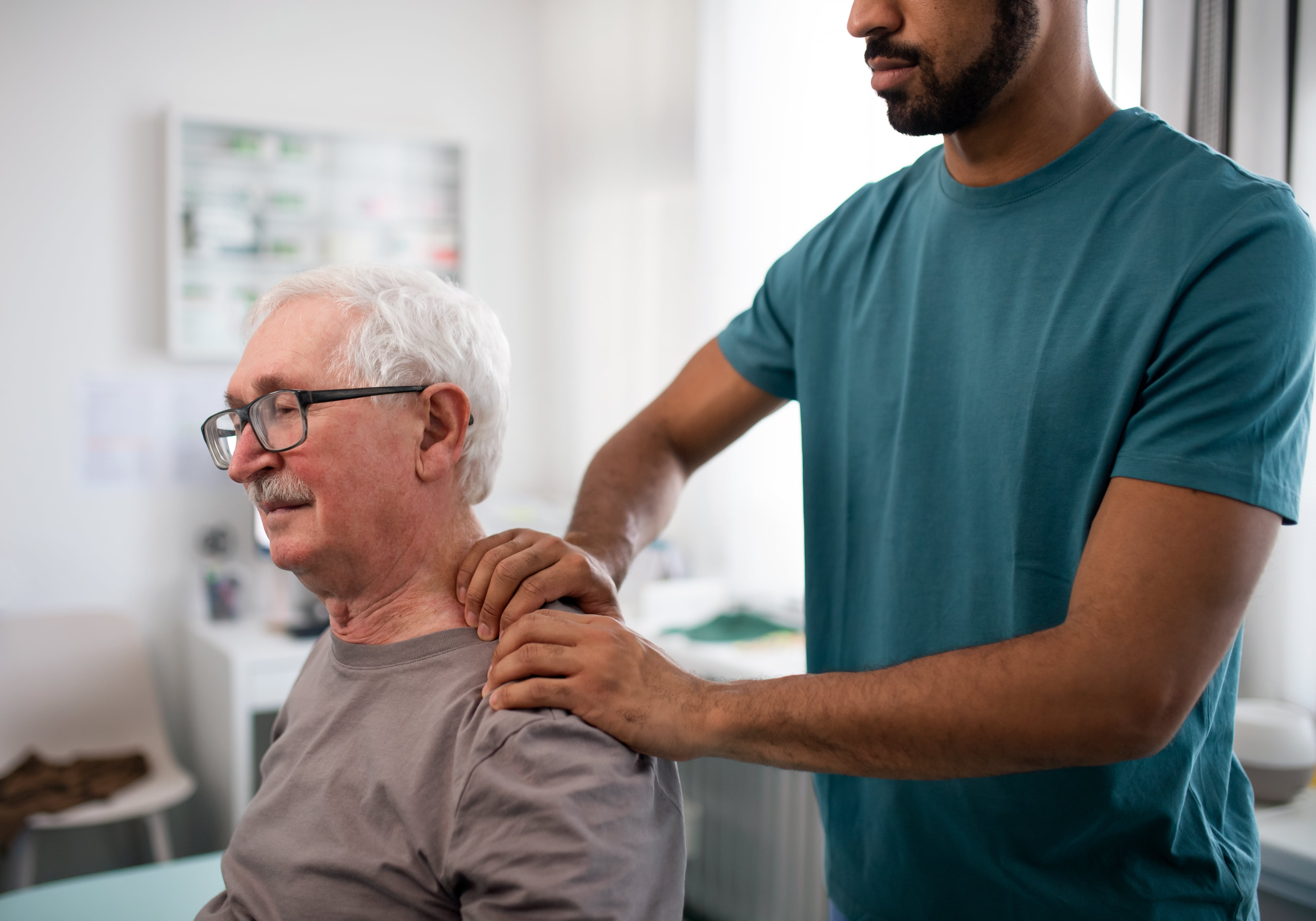 Massage therapy Osteopath Marrickville, shoulder pain in elderly gentlemen. He is sitting having massage on left shoulder.