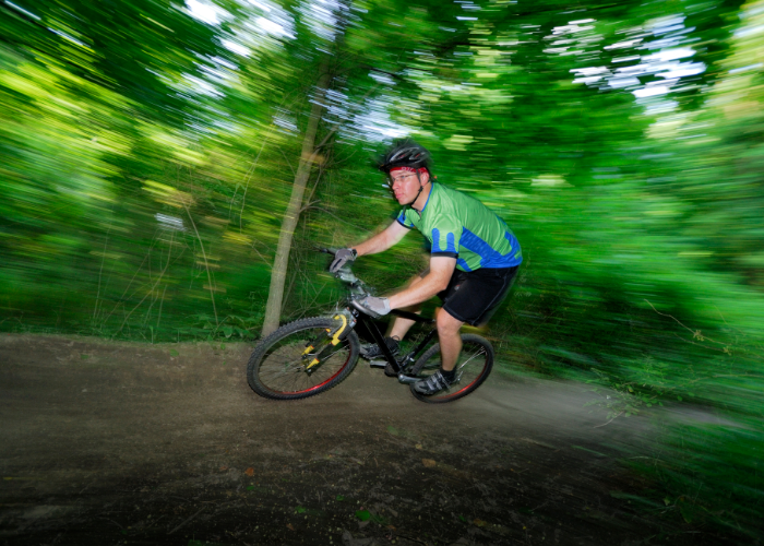 A mountain biker riding a mountain bike on a single track trail