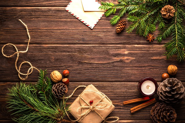 Wood table with Christmas cards, a present, and greenery.