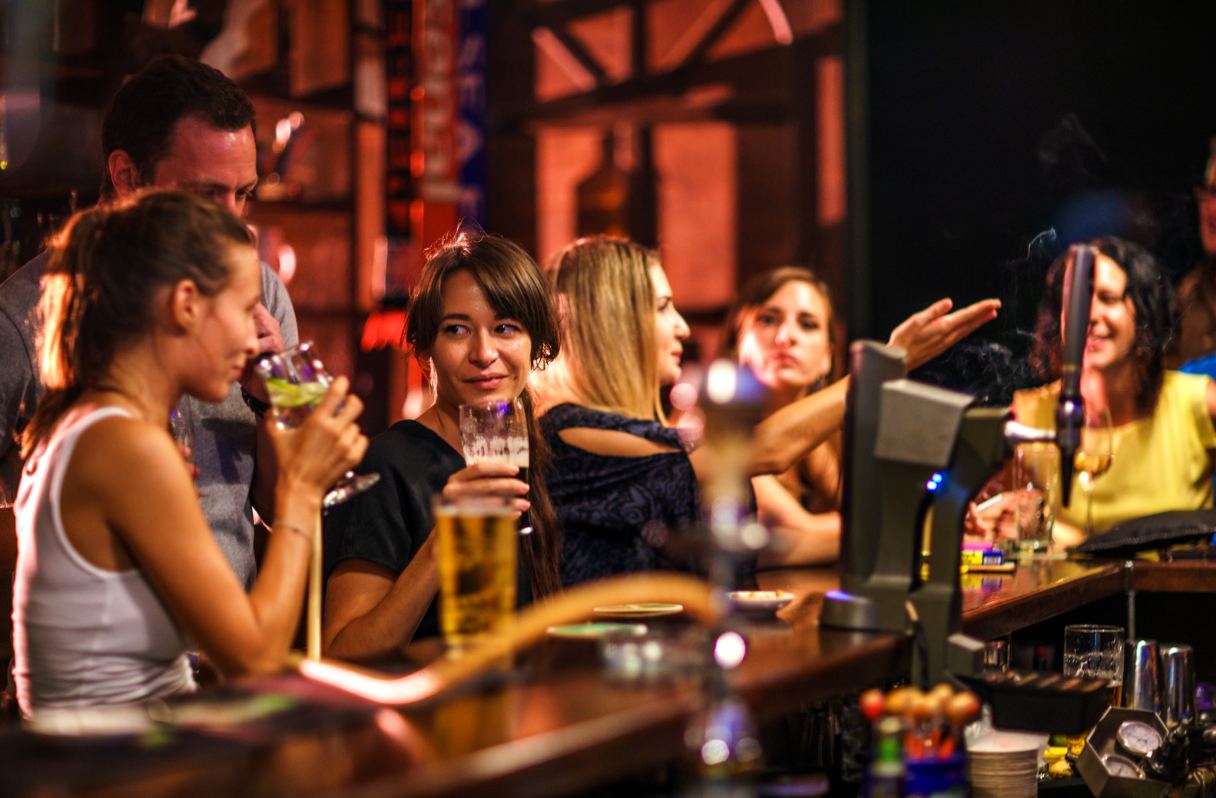 Young-people-drinking-socialising-stood-bar