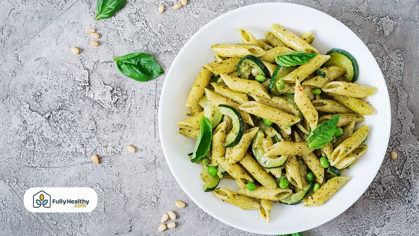 Plate of penne pasta with pesto, zucchini, and peas