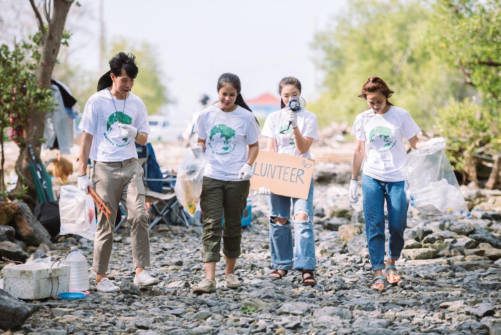 Group of people volunteering after a disaster, pulling together resources and trying to lower the extra costs.