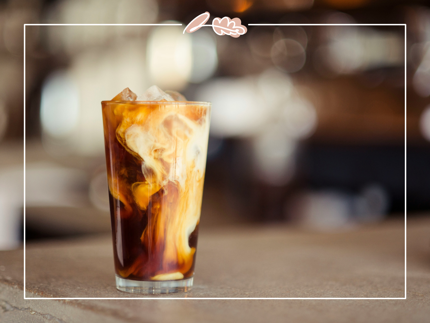 Iced coffee with cream swirling inside the glass on a countertop. Fabulous Flowers and Gifts